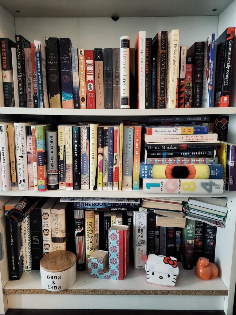 Books on three shelves of a bookcase.